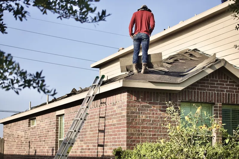 Professional roofer working on a residential roof in Petersville